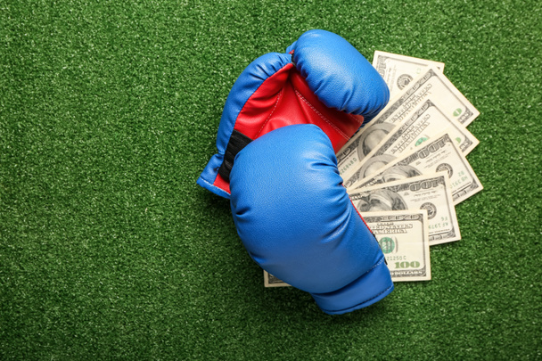 Dinheiro e luvas de boxe no fundo de cor. Conceito de aposta desportiva - Foto, Imagem
