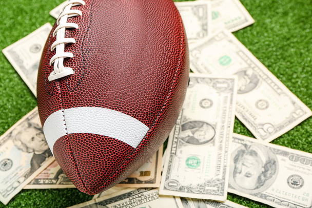 色の背景にお金とラグビーボール、クローズアップ。スポーツベットの概念 - 写真・画像