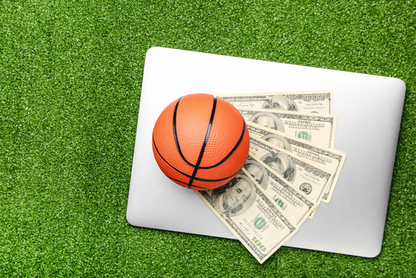 Peníze, notebook a míč pro hraní basketbalu na barevném pozadí. Pojetí sportovní sázky - Fotografie, Obrázek