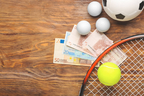 Money and balls on wooden background. Concept of sports bet - Foto, Imagen