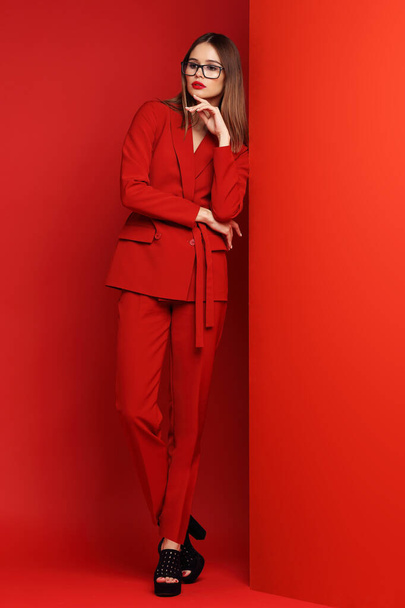 Fashion young woman in red suit. Red background. - Fotoğraf, Görsel