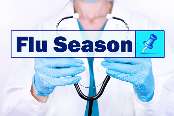 FLU SEASON text is written on the background of a doctor holding a stethoscope. Medical concept. - Fotografie, Obrázek
