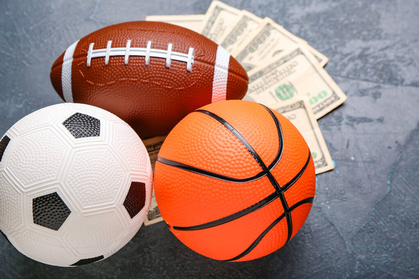 Money and balls on dark background. Concept of sports bet - Photo, Image