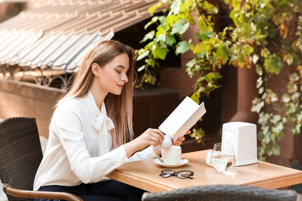 Красива жінка з порожньою книгою в кафе на відкритому повітрі
 - Фото, зображення