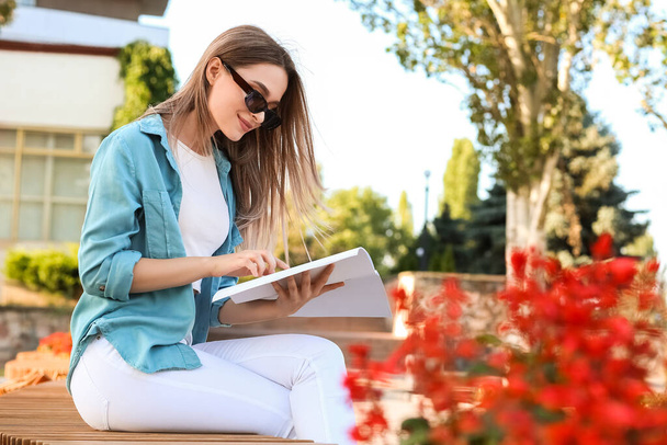 Hermosa mujer leyendo revista en blanco al aire libre - Foto, imagen
