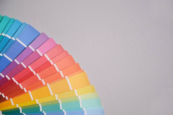 Oude kleurenpalet gids catalogus op een grijze muur. Huisschilder werktuig concept. - Foto, afbeelding