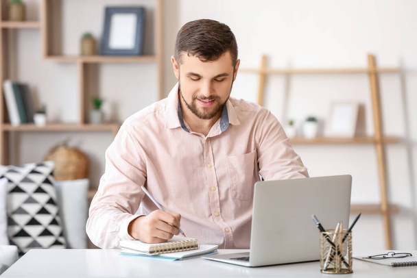 Fiatal férfi dolgozik laptop otthon - Fotó, kép