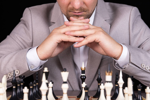Szachownica z człowiekiem myślącym o strategii szachowej - Zdjęcie, obraz