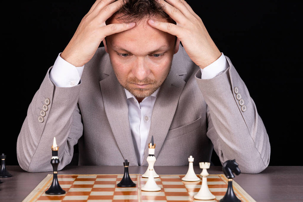 Chessboard with man thinking about chess strategy - Zdjęcie, obraz