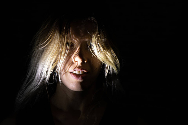 face of a girl with long hair in the dark, face silhouette - Foto, afbeelding