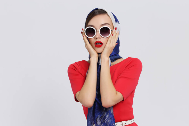 Young woman in retro style. Sunglasses and silk scarf. Sixties style fashion retro woman.  - Foto, Bild
