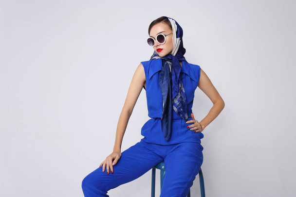 Young woman in retro style. Sunglasses and silk scarf, blue overalls. Sixties style fashion retro woman.  - Fotografie, Obrázek