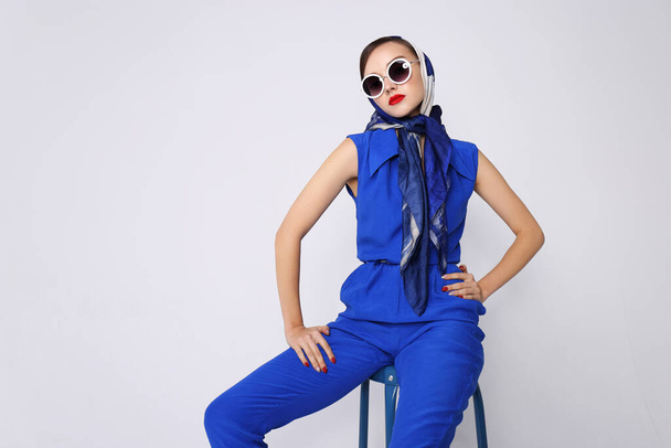 Jonge vrouw in retro stijl. Zonnebril en zijden sjaal, blauwe overall. jaren zestig stijl mode retro vrouw.  - Foto, afbeelding