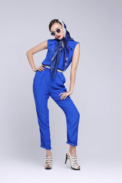 Young woman in retro style. Sunglasses and silk scarf, blue overalls. Sixties style fashion retro woman.  - Foto, Bild