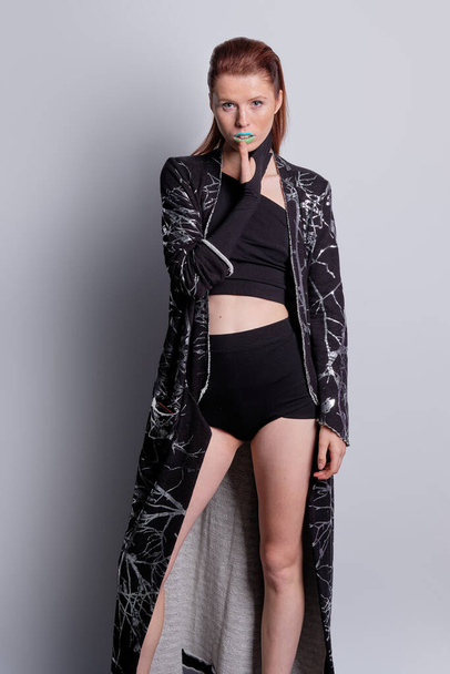 Fashion model in black coat with print and top and high waist briefs - Photo, Image