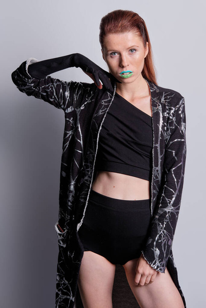 Fashion model in black coat with print and top and high waist briefs - Valokuva, kuva