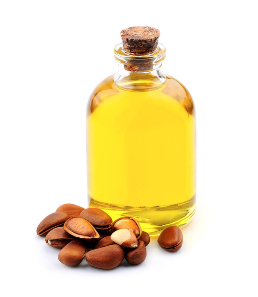 Cedar oil with pine nuts on white backgrounds.Healthy food ingredient. - 写真・画像