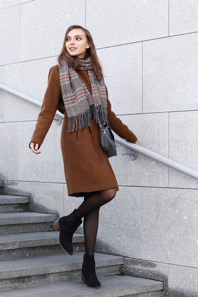 Fashion young woman outdoor. Wearing coat, scarf, and handbag  - Foto, Imagen