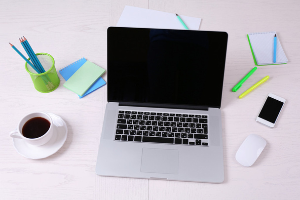 Office workplace with open laptop on wooden desk - Фото, зображення
