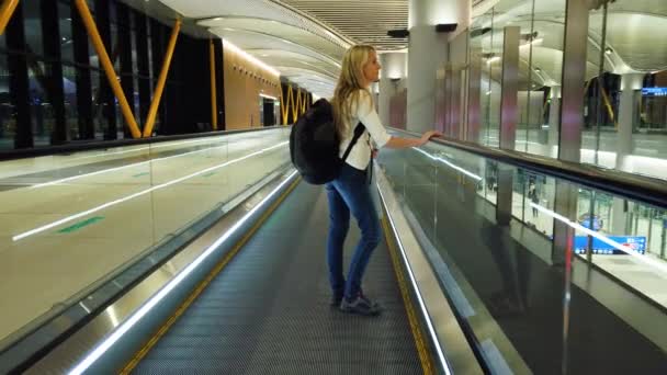Kobieta na ruchomych schodach na międzynarodowym lotnisku. - Materiał filmowy, wideo