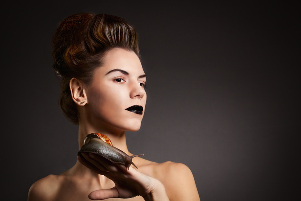 Brunette woman with snail with black eyes and lips. Fashion. Got - Valokuva, kuva