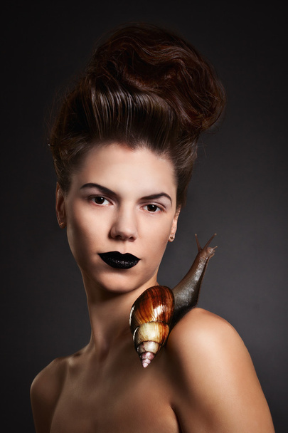Portrait of a woman with snail with black eyes and lips. Fashion - Zdjęcie, obraz