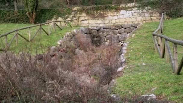 Покинутий болотистий старий штормовий водний дренажний канал на пагорбі з кам'яною стіною
 - Кадри, відео