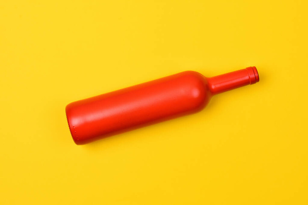 red glass bottle on yellow background - Photo, Image