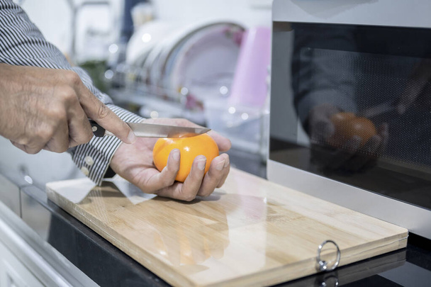 homme flou cuisine asiatique dans la cuisine de la maison Il mains coupant des légumes et des fruits dans la cuisine à grande main sur micro-ondes dans la cuisine fond flou - Photo, image