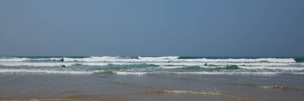 Люди з Корнуола, які розважаються хвилями і морем у заболочених костюмах з дошками для серфінгу на північному узбережжі Корнуола. - Фото, зображення