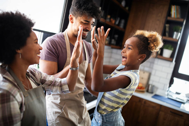 Happy african american family preparing healthy food in kitchen together - Foto, Bild