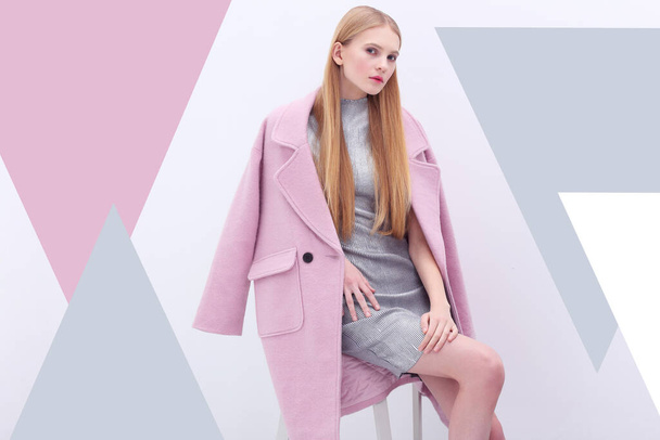 Young elegant woman in trendy pink coat. Blond hair, silver dress, isolated studio shot. - Zdjęcie, obraz