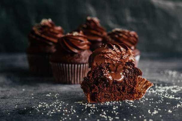 Delicious chocolate cupcakes. Cupcakes on a concrete table. Chocolate biscuit and chocolate ganache - Φωτογραφία, εικόνα