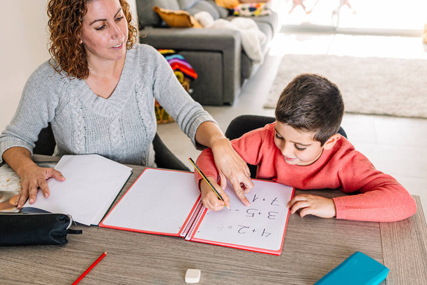 Madre aiutare suo figlio a fare matematica a casa - Foto, immagini
