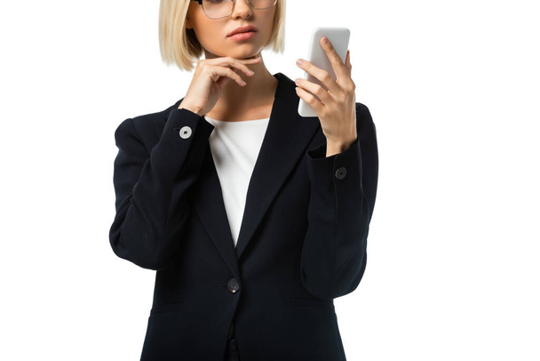 частковий вид бізнес-леді торкається підборіддя, тримаючи смартфон ізольований на білому
 - Фото, зображення