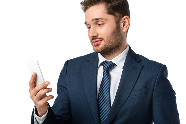 young positive businessman holding smartphone isolated on white - Foto, imagen