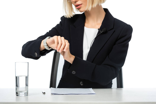 oříznutý pohled na ukotvení ženy při kontrole času na hodinkách na pracovišti izolovaném na bílém - Fotografie, Obrázek