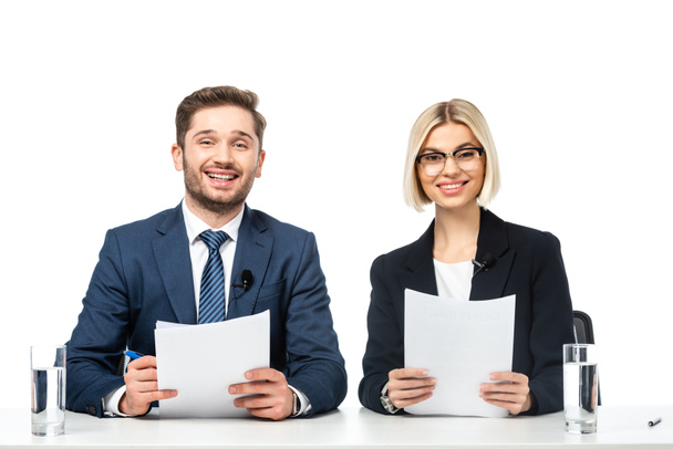 news presenters smiling at camera while holding papers at workplace isolated on white - Photo, Image