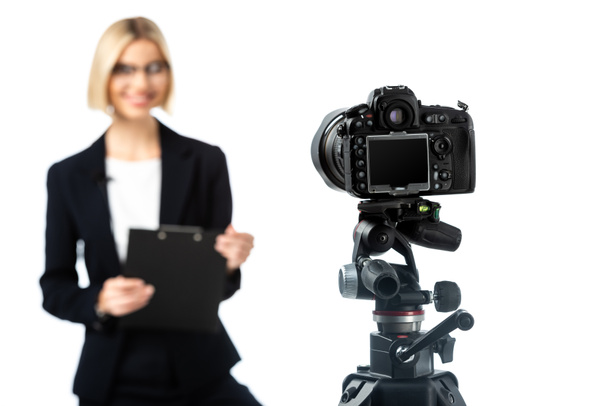 selective focus of digital camera near news anchor with clipboard on blurred background isolated on white - Foto, Imagem