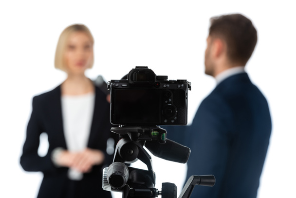 selective focus of digital camera near couple of news anchors on blurred background isolated on white - Photo, Image