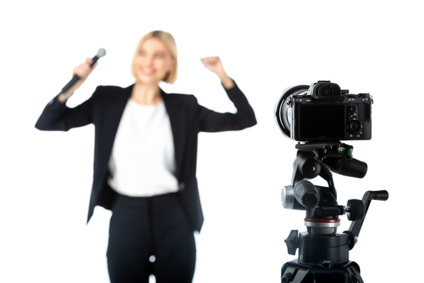 selective focus of digital camera near news anchor showing success gesture on blurred background isolated on white - Photo, Image