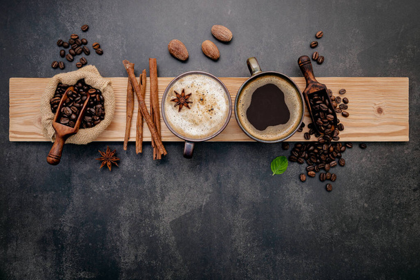 Pražená kávová zrna s kávovým práškem a aromatické složky pro výrobu chutné kávy nastavení na tmavém kamenném pozadí. - Fotografie, Obrázek