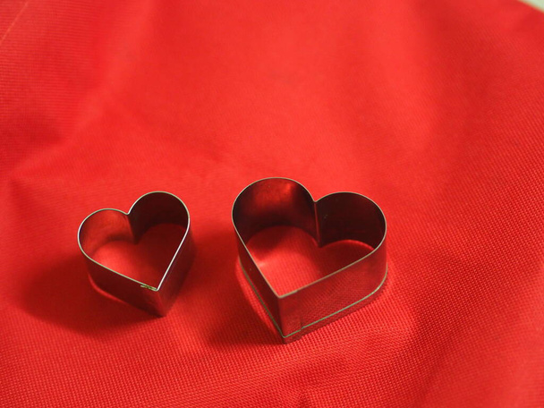 couple bread molds stainless Heart shaped on fabric red background, love Valentine Day for copy text card, background - Fotografie, Obrázek