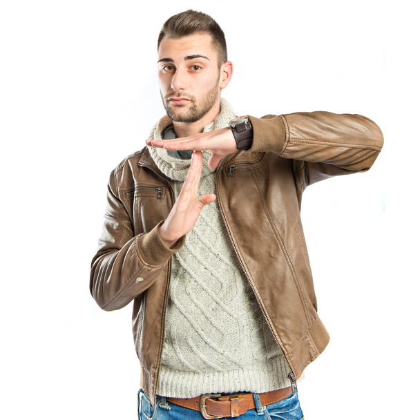 Handsome man doing the timeout sign over white background  - Photo, Image