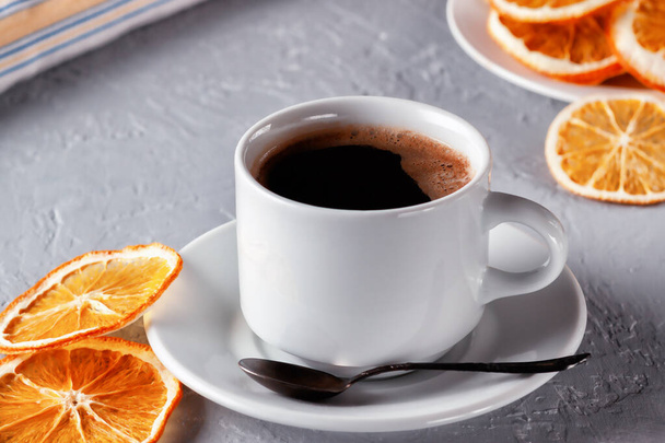 Cup of freshly brewed coffee with dried oranges on the table - Foto, Bild