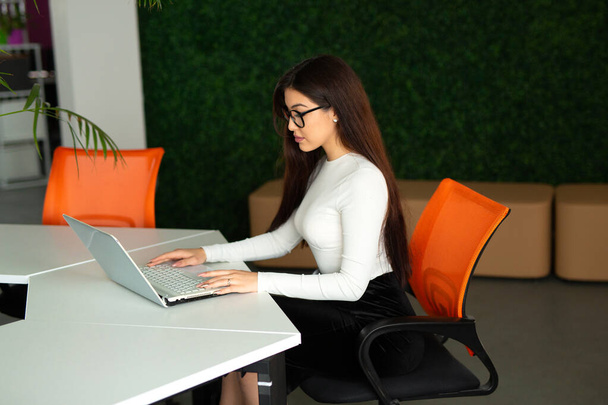 beautiful young woman at the table with laptop in the office - Foto, imagen