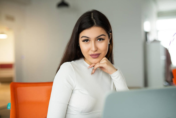beautiful young woman at the table with laptop in the office - Foto, afbeelding