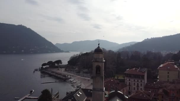 Aerial drone shot historiallisen kirkon lähellä satamaa Como Lake, Italia - Materiaali, video