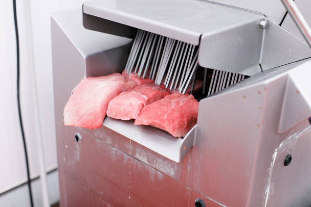Coupes fraîches et crues de viande hachée, introduites dans un lavage d'introduction dans le processus de production de viande. Société de viande, aliments de l'industrie. - Photo, image