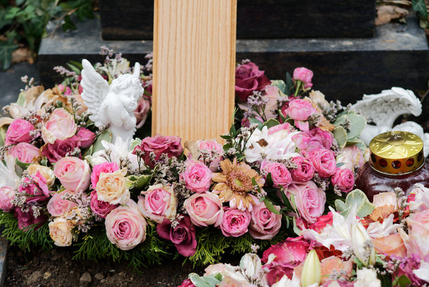 ghirlanda funebre con rose e un angelo su una tomba dopo un funerale - Foto, immagini